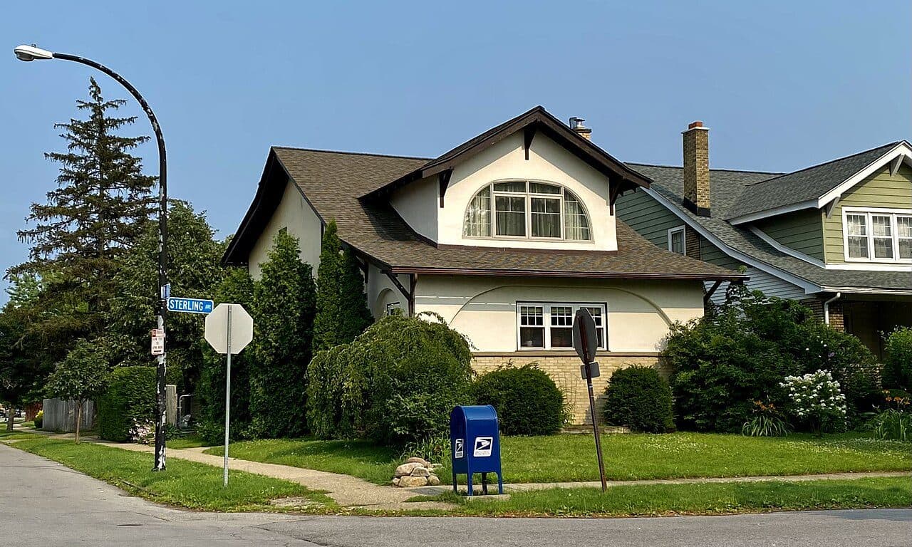 Two-story bungalow on a corner lot with a brown shingle roof