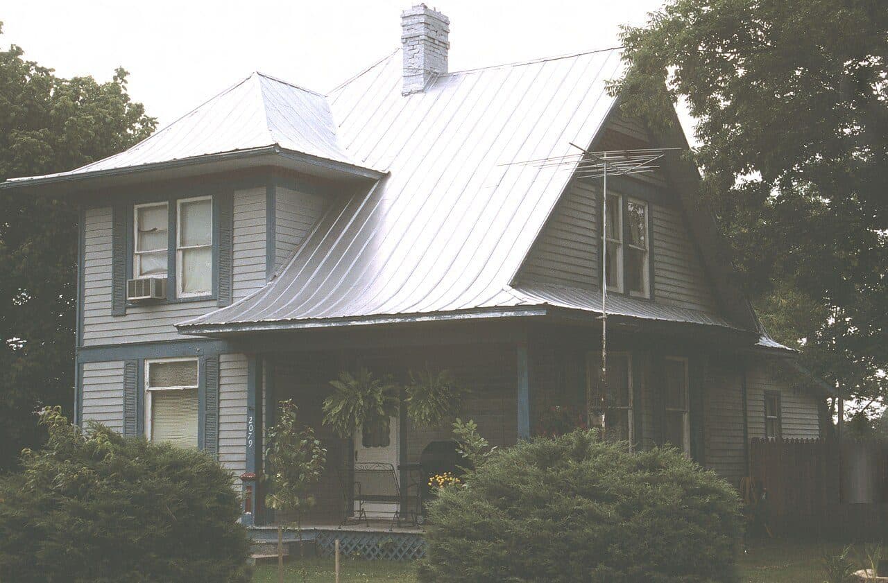 Two-story farmhouse with a silver standing-seam metal roof